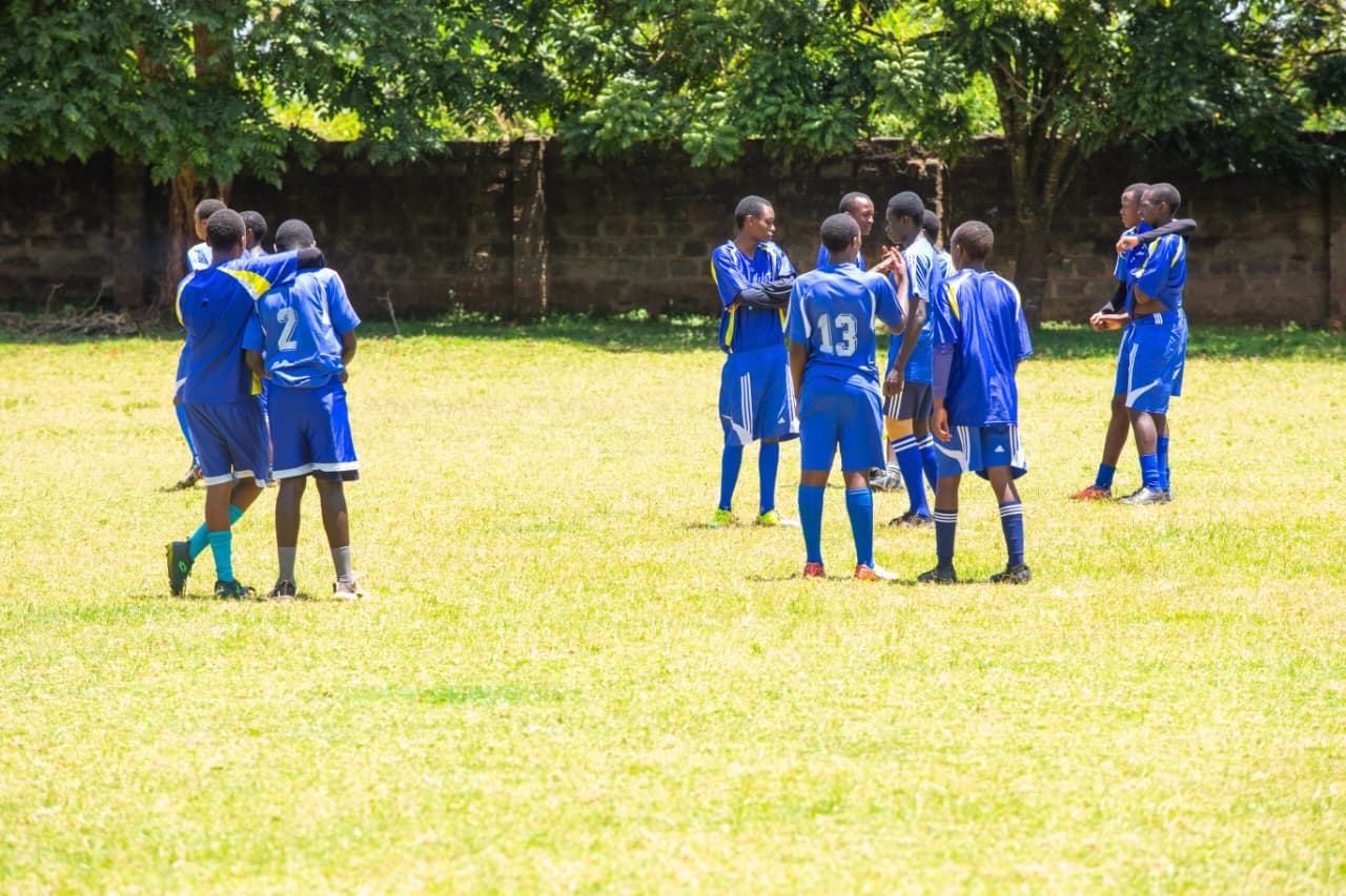 Students playing football on well-maintained field developing teamwork and sportsmanship